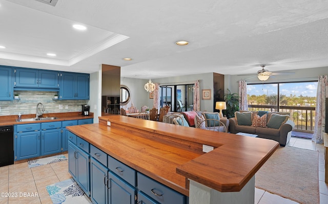 kitchen featuring ceiling fan with notable chandelier, blue cabinets, butcher block counters, and sink