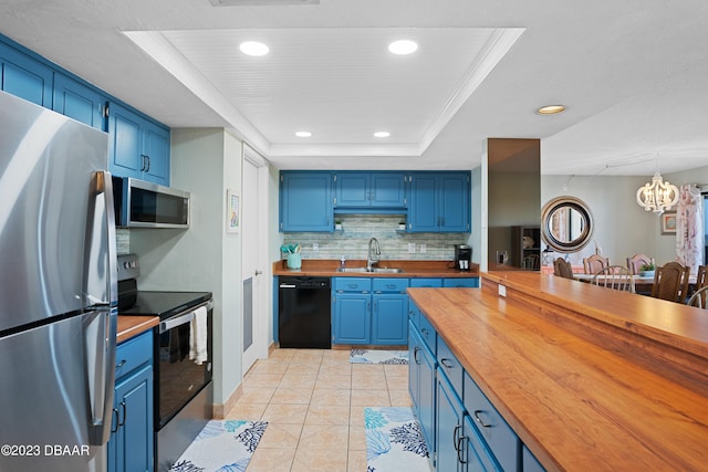 kitchen featuring a notable chandelier, blue cabinetry, appliances with stainless steel finishes, and a tray ceiling