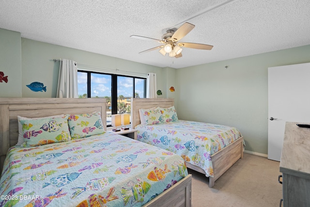 bedroom featuring a textured ceiling, ceiling fan, and light carpet