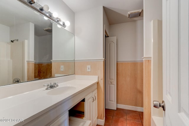 bathroom featuring tile patterned floors, wooden walls, and vanity