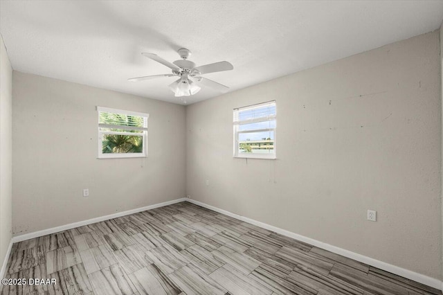 empty room featuring ceiling fan, a healthy amount of sunlight, and a textured ceiling