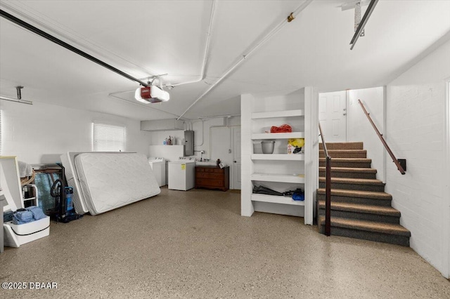 garage with a garage door opener, washing machine and clothes dryer, and electric panel