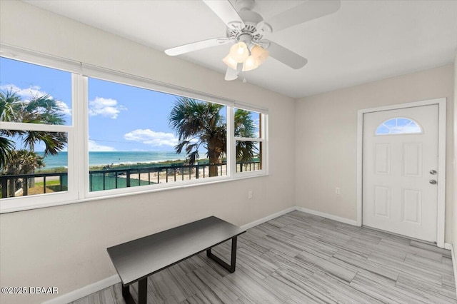 entryway featuring ceiling fan, a water view, and light hardwood / wood-style floors