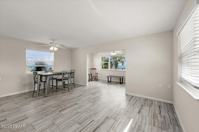 dining area with ceiling fan, a healthy amount of sunlight, and light wood-type flooring