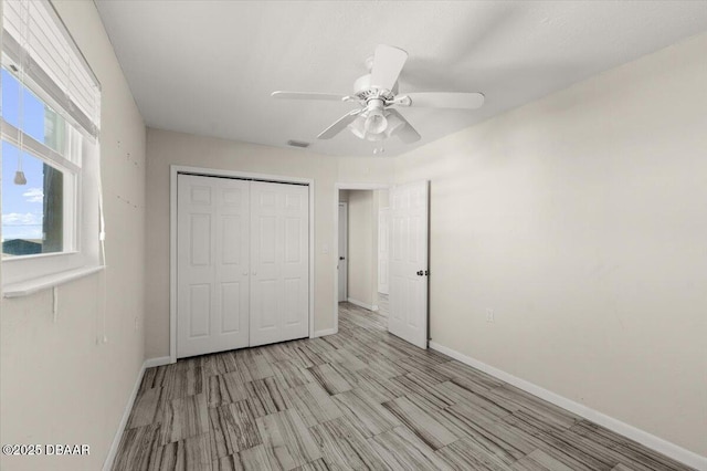 unfurnished bedroom featuring ceiling fan and a closet