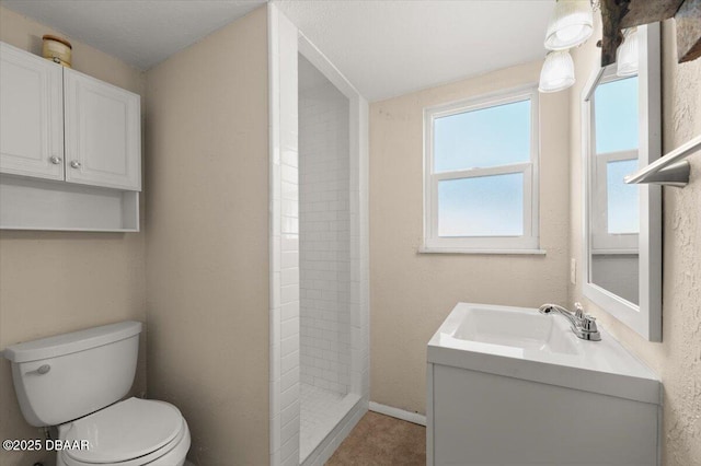 bathroom with vanity, a shower, and toilet