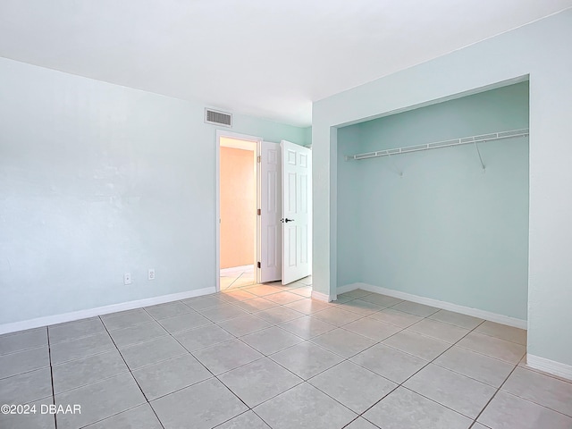 unfurnished bedroom featuring light tile patterned floors and a closet