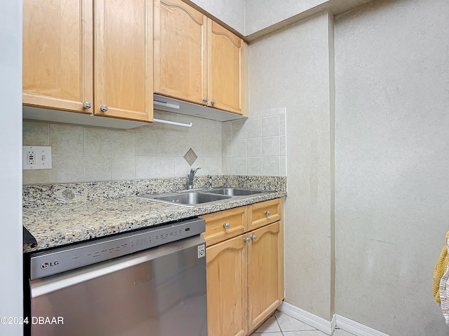 kitchen featuring light tile patterned flooring, sink, light stone counters, tasteful backsplash, and stainless steel dishwasher