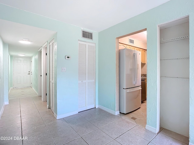 hall with light tile patterned floors