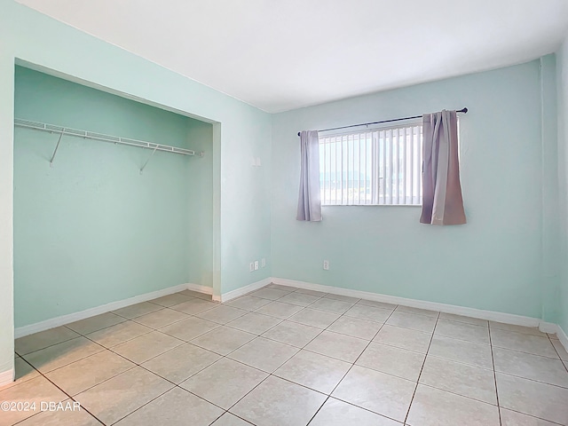 unfurnished bedroom featuring light tile patterned floors and a closet