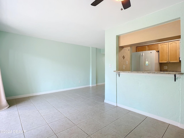 kitchen featuring light tile patterned floors and white refrigerator