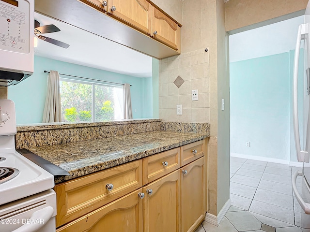 kitchen featuring light tile patterned floors and dark stone countertops