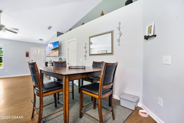 dining room with hardwood / wood-style flooring, ceiling fan, and vaulted ceiling