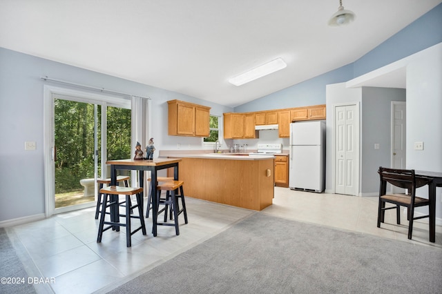 kitchen featuring light carpet, a breakfast bar, kitchen peninsula, white appliances, and lofted ceiling