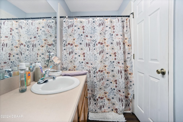 bathroom featuring hardwood / wood-style flooring, vanity, and walk in shower