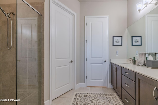 bathroom featuring a tile shower, vanity, and tile patterned floors