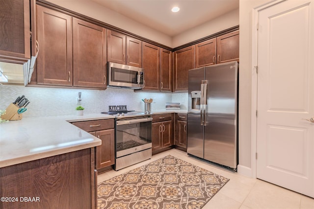 kitchen with dark brown cabinets, decorative backsplash, appliances with stainless steel finishes, and light tile patterned floors