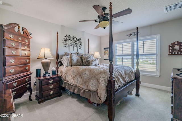 bedroom featuring a textured ceiling, light carpet, and ceiling fan