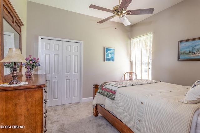 bedroom featuring light carpet, ceiling fan, and a closet