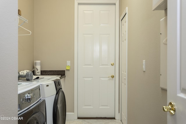 laundry area with washer and clothes dryer and light tile patterned flooring