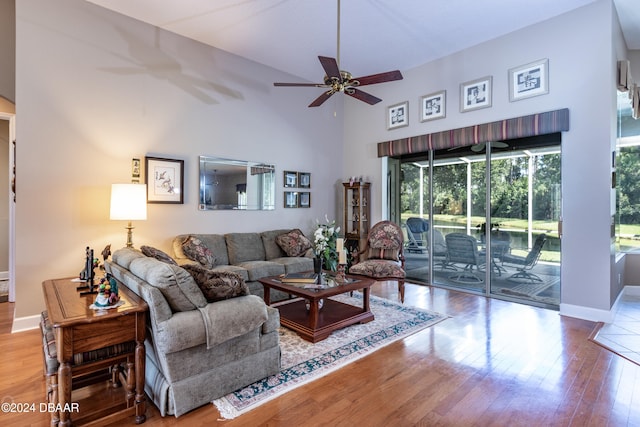 living room featuring hardwood / wood-style floors, a high ceiling, and ceiling fan