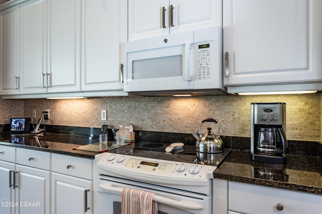 kitchen with white appliances, decorative backsplash, and white cabinets