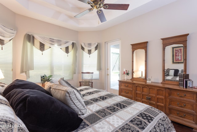 bedroom with access to outside, ceiling fan, and a raised ceiling