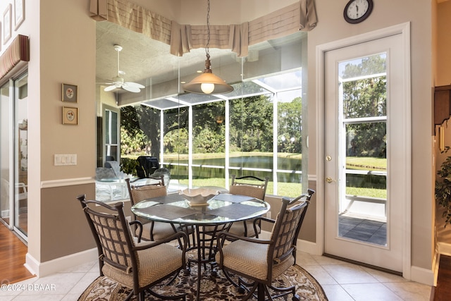 sunroom / solarium featuring a water view and ceiling fan