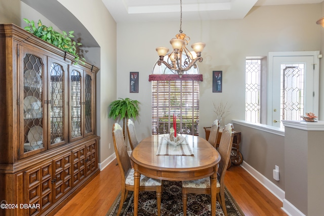 dining space with wood-type flooring and a notable chandelier