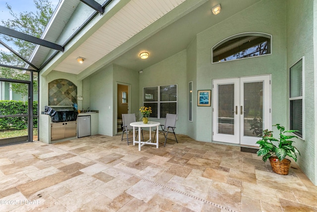 view of patio / terrace with french doors, sink, area for grilling, glass enclosure, and exterior kitchen