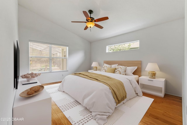 bedroom featuring ceiling fan, lofted ceiling, and light hardwood / wood-style flooring