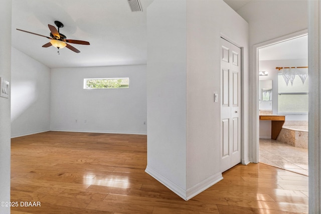 spare room with ceiling fan and light wood-type flooring