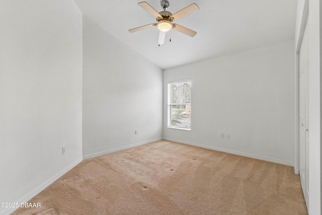 carpeted empty room featuring ceiling fan and vaulted ceiling