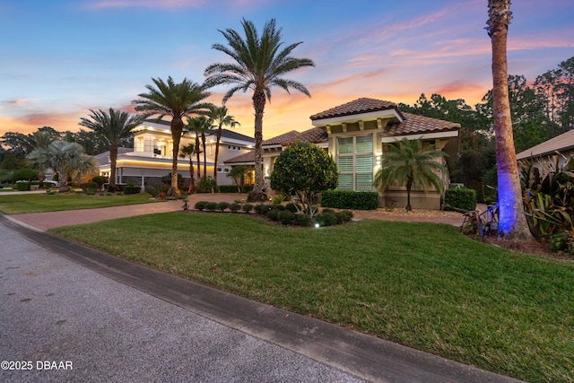 650 Woodbridge Dr, Ormond Beach, FL 32174 - mediterranean / spanish house featuring a tiled roof, stucco siding, a front yard, and driveway
