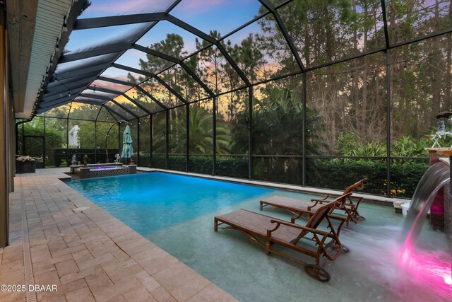 650 Woodbridge Dr, Ormond Beach, FL 32174 - pool at dusk with a patio, a pool with connected hot tub, and a lanai