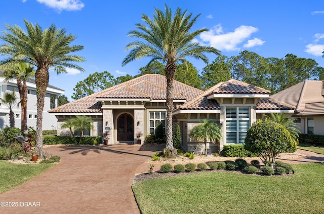 650 Woodbridge Dr, Ormond Beach, FL 32174 - mediterranean / spanish home featuring a tiled roof, stucco siding, decorative driveway, and a front yard