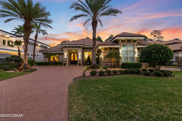 650 Woodbridge Dr, Ormond Beach, FL 32174 - mediterranean / spanish home with curved driveway, stucco siding, a lawn, and a tile roof