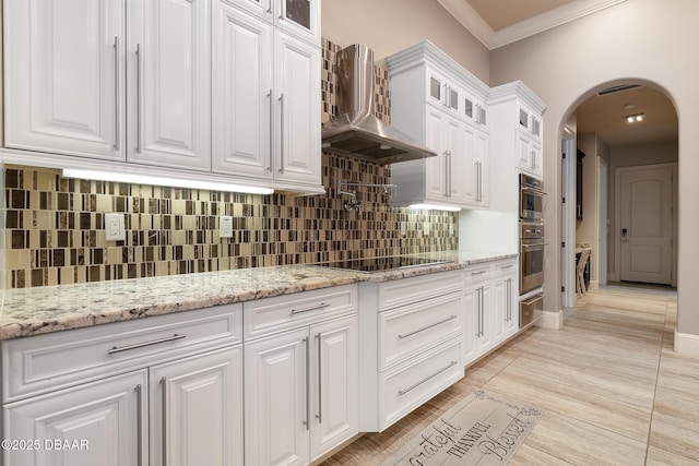 650 Woodbridge Dr, Ormond Beach, FL 32174 - kitchen featuring black electric stovetop, crown molding, arched walkways, white cabinets, and tasteful backsplash