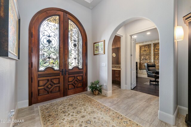 650 Woodbridge Dr, Ormond Beach, FL 32174 - foyer entrance with arched walkways, french doors, healthy amount of natural light, and baseboards