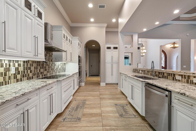 650 Woodbridge Dr, Ormond Beach, FL 32174 - kitchen featuring appliances with stainless steel finishes, a sink, arched walkways, wall chimney range hood, and crown molding