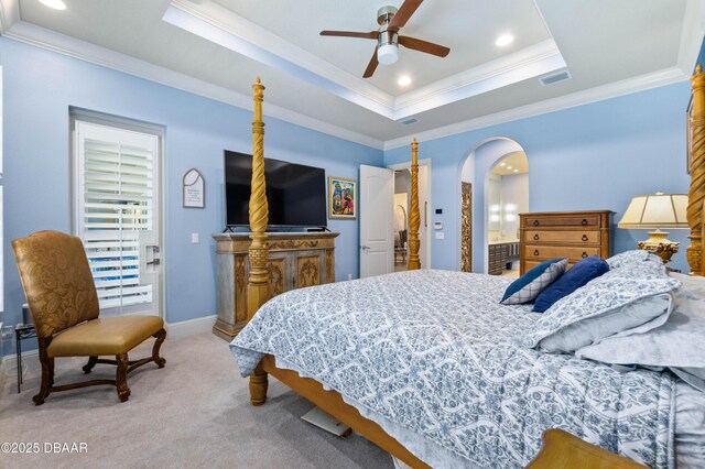 650 Woodbridge Dr, Ormond Beach, FL 32174 - bedroom with arched walkways, crown molding, light colored carpet, a tray ceiling, and ceiling fan