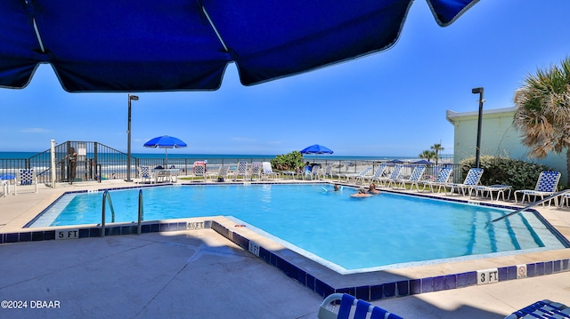 view of swimming pool with a patio area and a water view