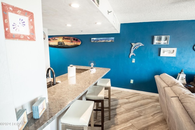 2615 S Atlantic Ave Unit 5C, Daytona Beach Shores, FL 32118 - dining area featuring an accent wall, recessed lighting, baseboards, and a textured ceiling