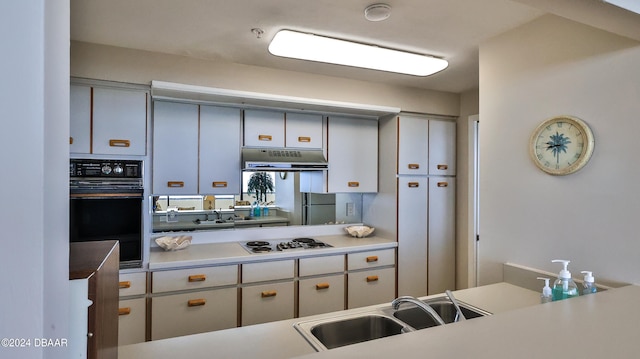 kitchen with white gas cooktop, black oven, sink, and refrigerator