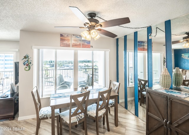 dining room with a textured ceiling, light hardwood / wood-style flooring, and ceiling fan