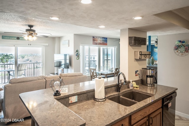2615 S Atlantic Ave Unit 5C, Daytona Beach Shores, FL 32118 - kitchen with a sink, dishwasher, light stone counters, a ceiling fan, and brown cabinets
