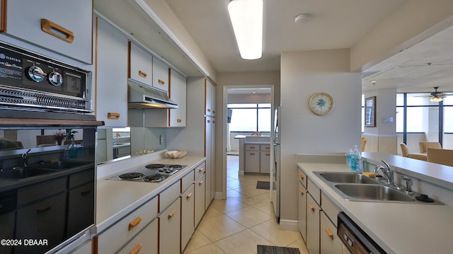 kitchen with light tile patterned flooring, a healthy amount of sunlight, sink, and white cabinetry