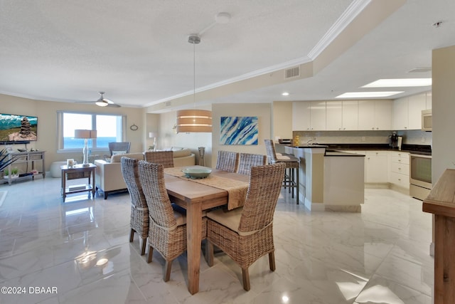 dining area featuring crown molding, ceiling fan, and a textured ceiling