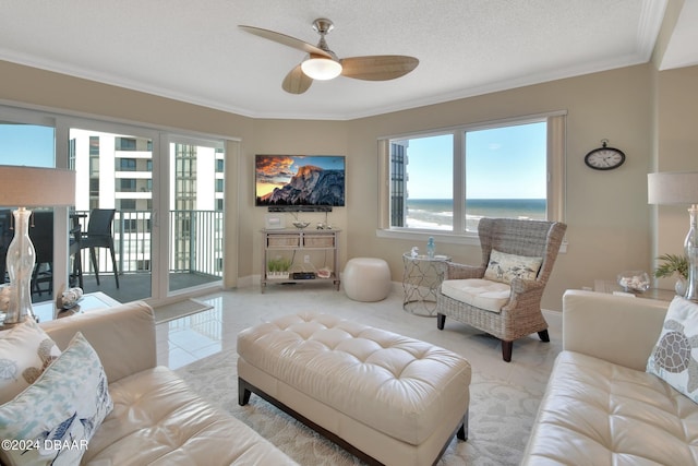 tiled living room featuring a textured ceiling, ceiling fan, and crown molding