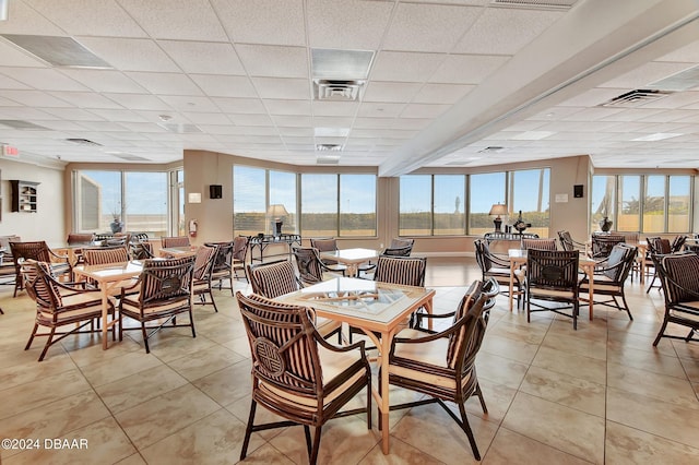 tiled dining area with a drop ceiling